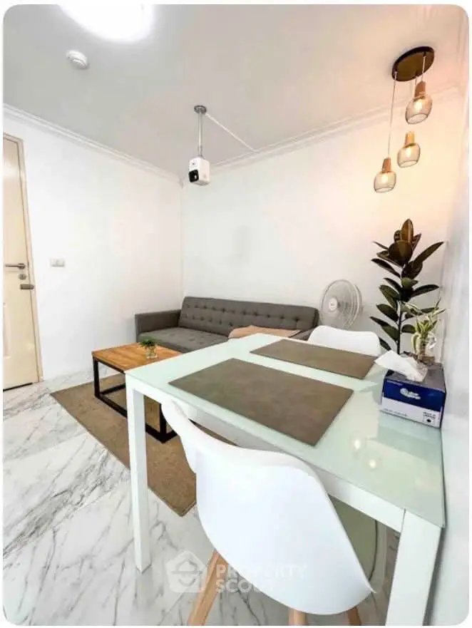 Modern living room with stylish decor and marble flooring, featuring a cozy sofa and elegant lighting.