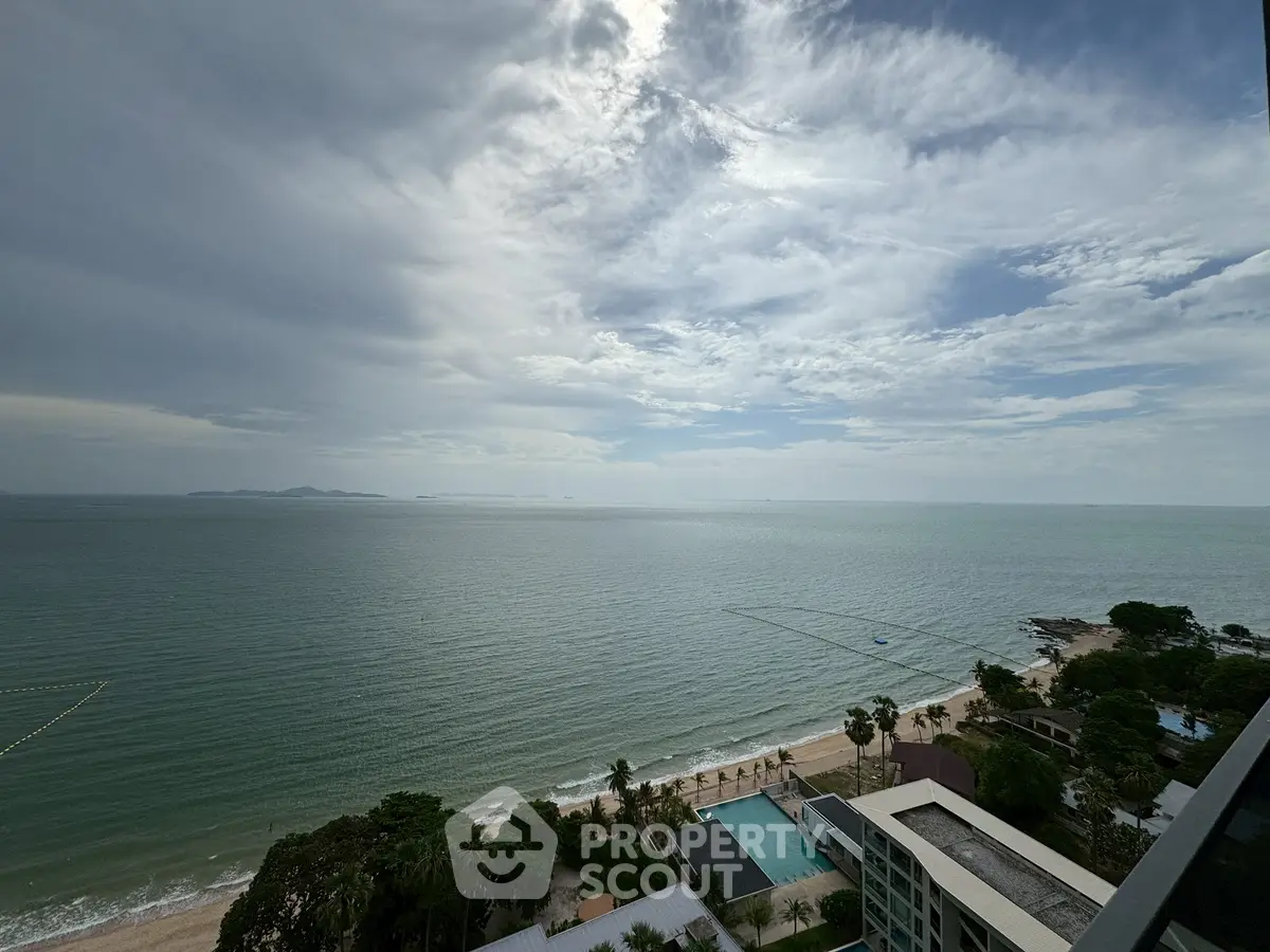Stunning ocean view from high-rise balcony with clear skies and serene beach