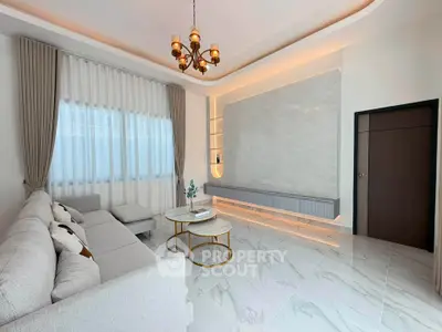 Elegant living room with modern decor, featuring a stylish chandelier and luxurious marble flooring.