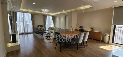 Spacious modern living room with elegant dining area and large windows offering natural light.