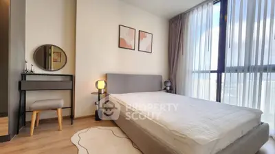 Modern bedroom with large window and stylish decor in a high-rise apartment.