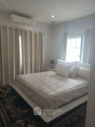 Cozy bedroom with elegant decor and natural light, featuring a comfortable bed and stylish curtains.
