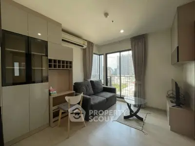 Modern living room with city view, featuring sleek furniture and large windows.