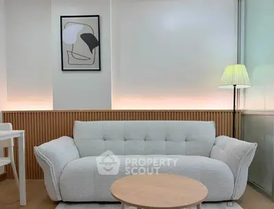 Modern living room with stylish sofa and abstract art, perfect for contemporary living.