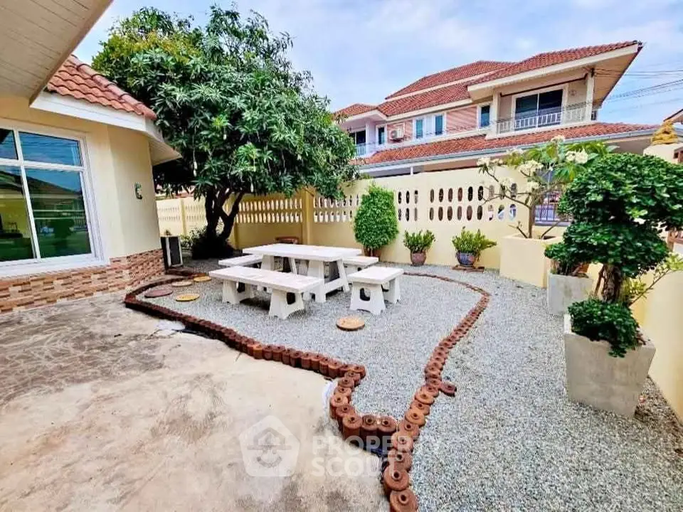 Charming garden area with seating in a suburban home, perfect for outdoor relaxation and gatherings.