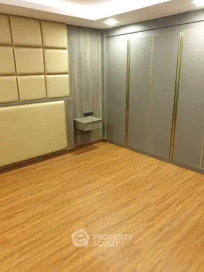 Modern bedroom with elegant wood flooring and stylish wall paneling