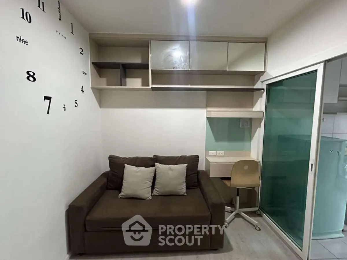 Cozy living room with modern shelving and sliding glass door, perfect for compact urban living.