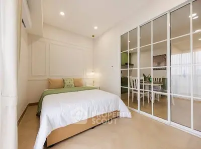 Spacious bedroom with elegant decor and sliding glass doors leading to a dining area.