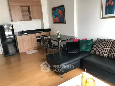 Modern living room with open kitchen, stylish decor, and cozy seating area in a contemporary apartment.