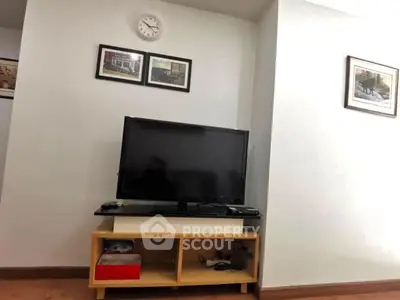 Cozy living room corner with TV and wall art, perfect for relaxation.