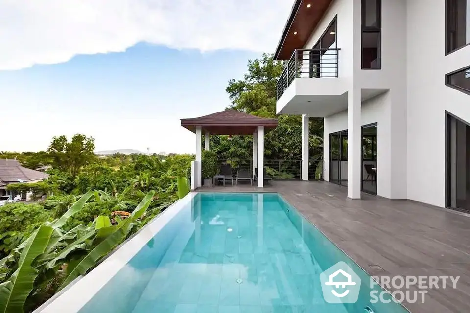 Luxurious modern villa with infinity pool and lush greenery view