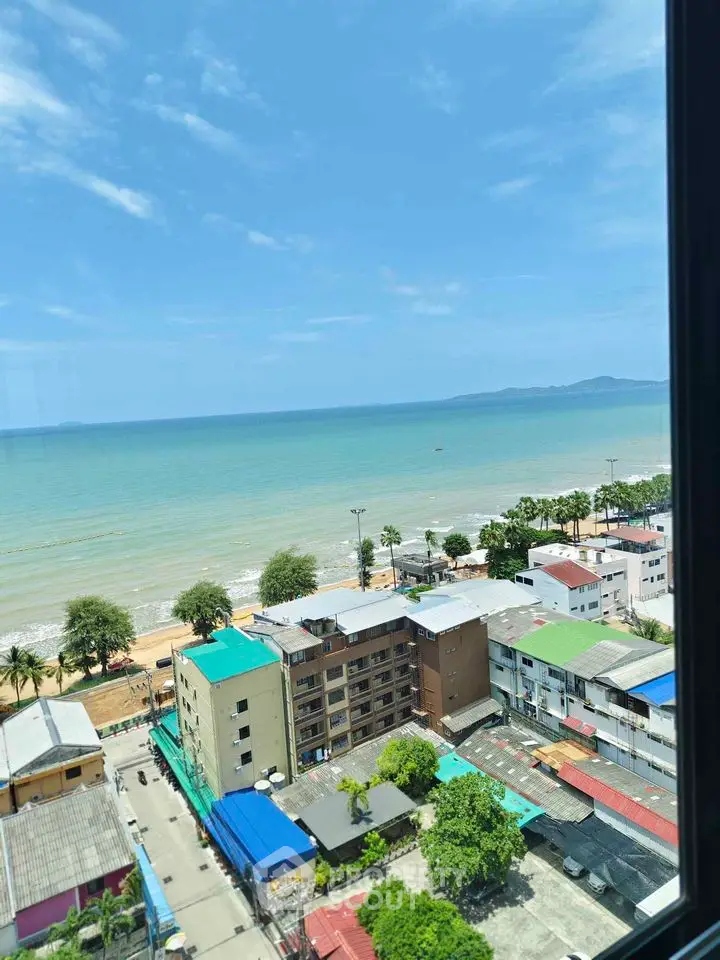 Stunning ocean view from high-rise building overlooking beach and cityscape.