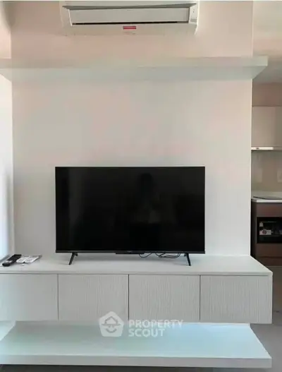 Modern living room with sleek TV setup and air conditioning unit, perfect for comfortable living.