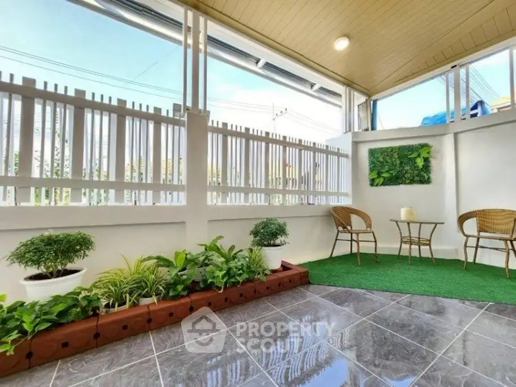 Charming garden patio with seating and lush greenery, perfect for relaxation.