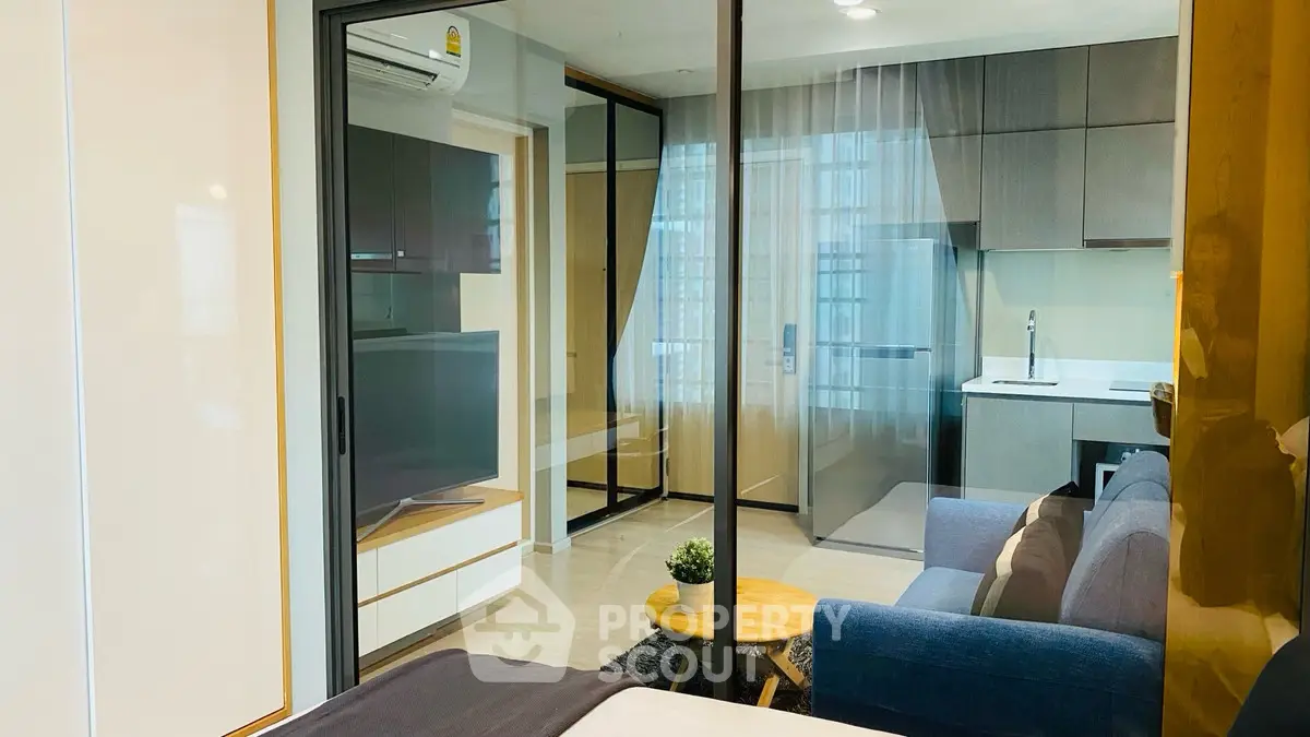 Modern open-plan living room with sleek kitchen and cozy seating area.