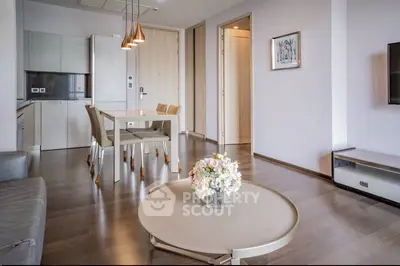 Modern living room with open kitchen, stylish decor, and elegant dining area in a contemporary apartment.