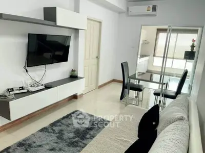Modern living room with sleek furniture and wall-mounted TV, featuring a cozy dining area.