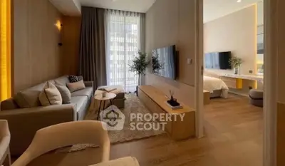 Modern living room with cozy seating and stylish decor leading to a chic bedroom.