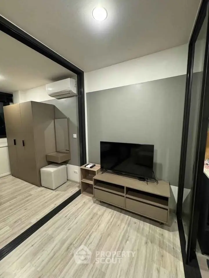 Modern living room with sleek furniture and TV setup in a stylish apartment.