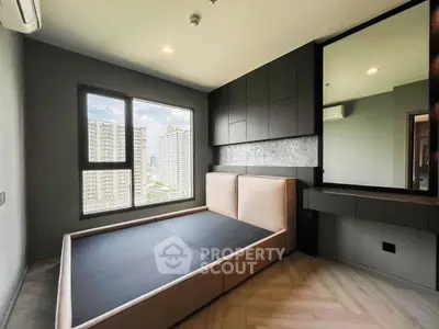 Modern bedroom with large window and built-in storage in urban apartment