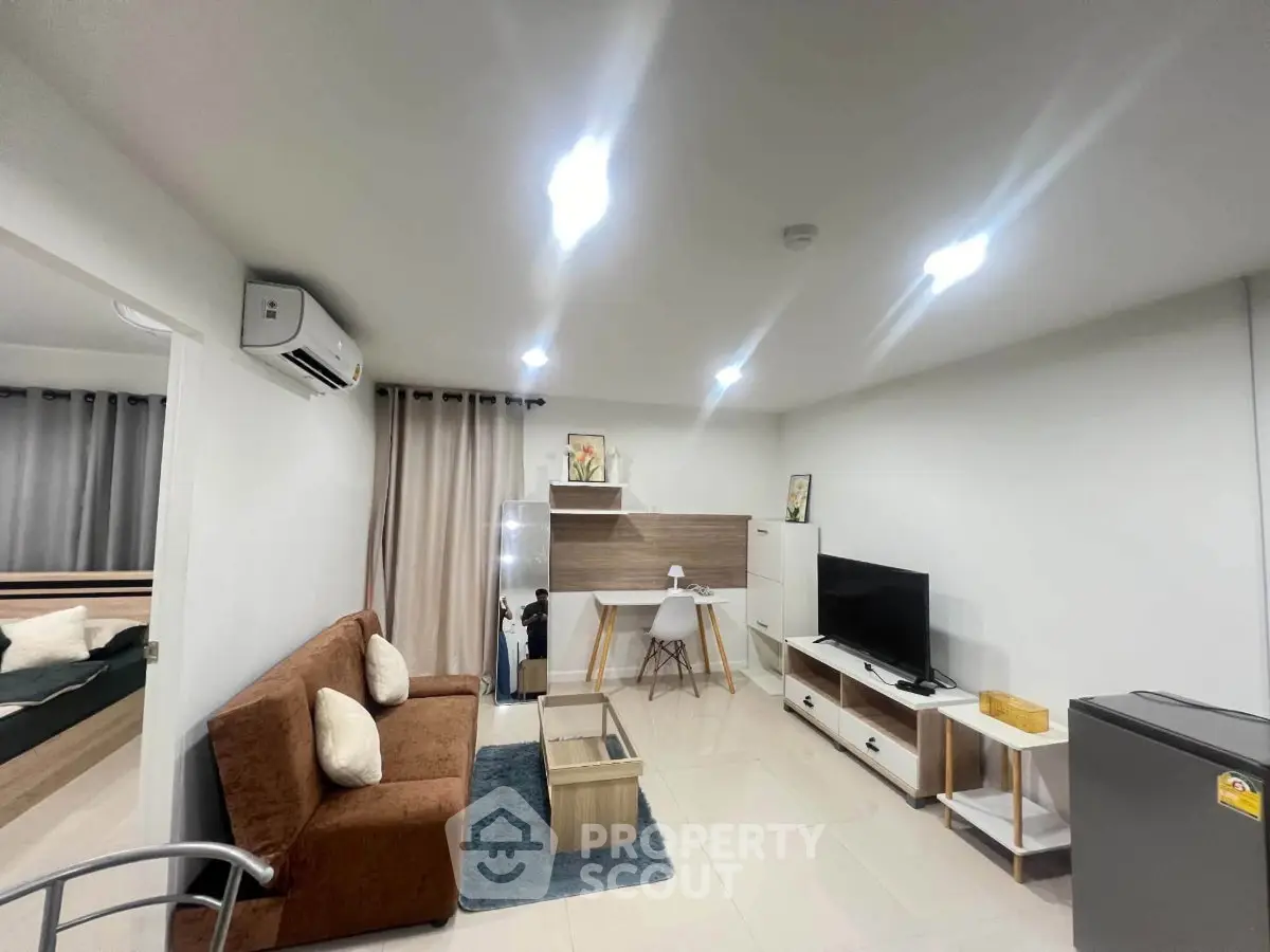 Modern living room with stylish furniture and open layout, featuring a cozy sofa and entertainment center.