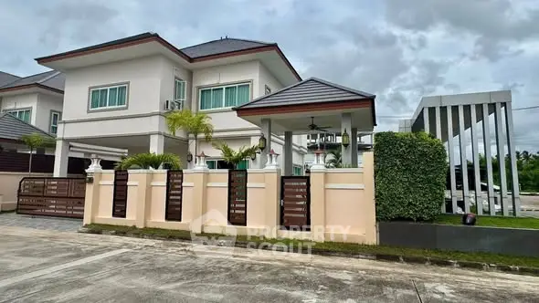 Elegant two-story house with modern design and lush greenery in a serene neighborhood.