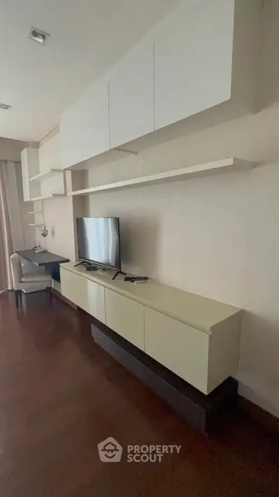 Modern living room with sleek TV unit and stylish shelving in a contemporary apartment.