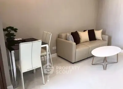 Modern living room with beige sofa, stylish coffee table, and dining area in open layout.