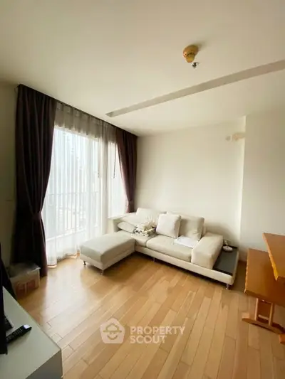 Bright living room with wooden flooring and large window in modern apartment