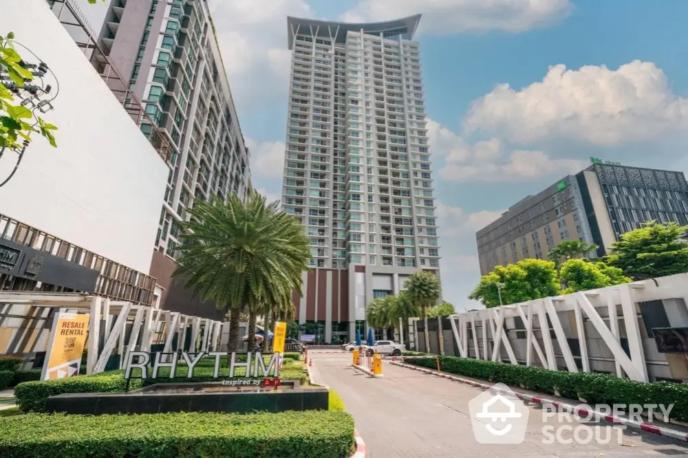 Modern high-rise condominium with lush landscaping and clear blue sky.