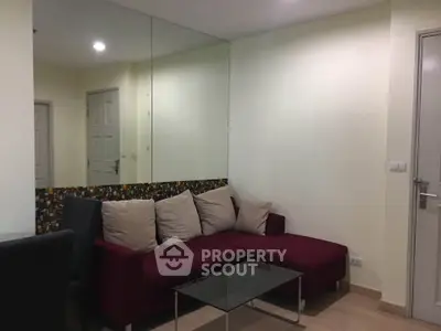 Cozy living room with modern red sofa and glass coffee table, perfect for relaxation.