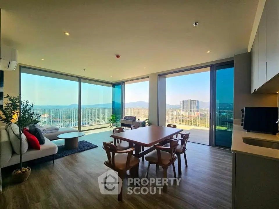 Spacious modern living room with panoramic city view and elegant dining area
