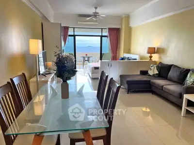 Spacious living room with ocean view, modern furniture, and elegant dining area in a coastal apartment.
