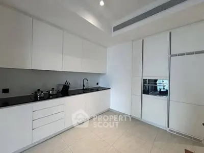 Modern kitchen with sleek white cabinetry and built-in appliances, perfect for contemporary living.