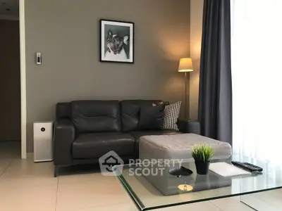 Modern living room with leather sofa, stylish decor, and natural light