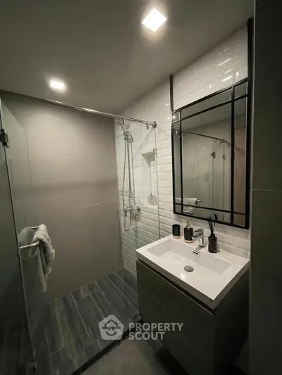 Modern bathroom with sleek design, featuring a glass shower and stylish vanity.