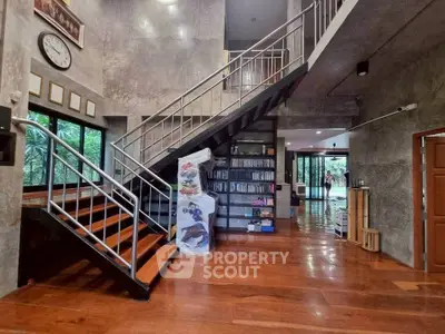 Spacious modern living room with wooden floors and stylish staircase