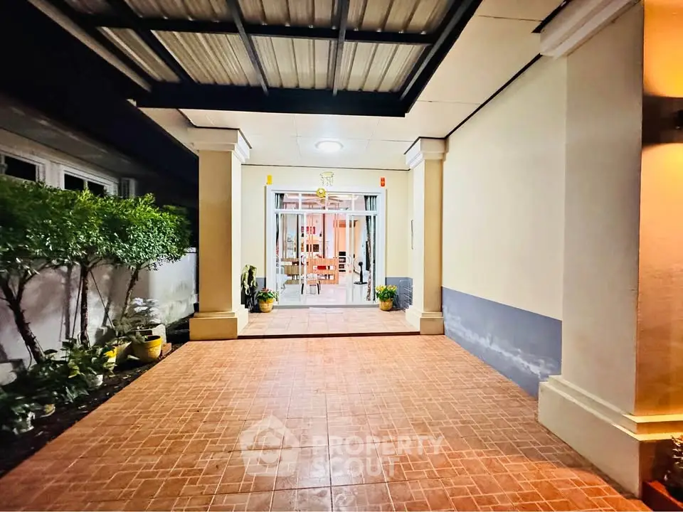Elegant entrance with tiled flooring and lush greenery, perfect for welcoming guests.
