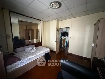 Cozy bedroom with wooden flooring and mirrored wardrobe in a compact space