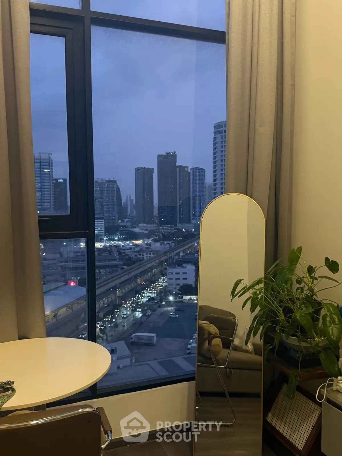 Modern apartment with stunning city view, featuring floor-to-ceiling windows and stylish decor.