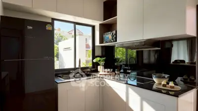 Modern kitchen with sleek black appliances and large window view.