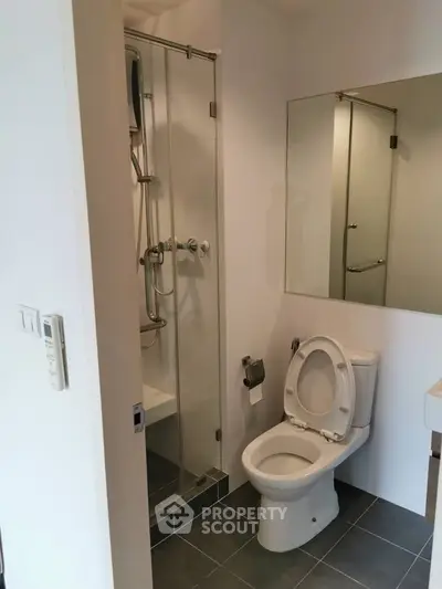 Modern bathroom with glass shower and sleek fixtures in a contemporary apartment.