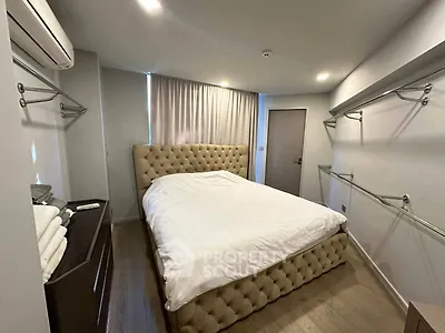 Spacious bedroom with elegant tufted bed and modern decor