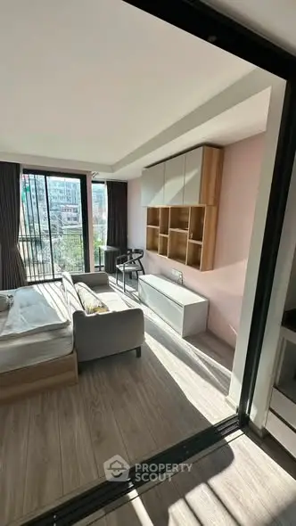 Modern living room with large windows and stylish furniture in a bright apartment.