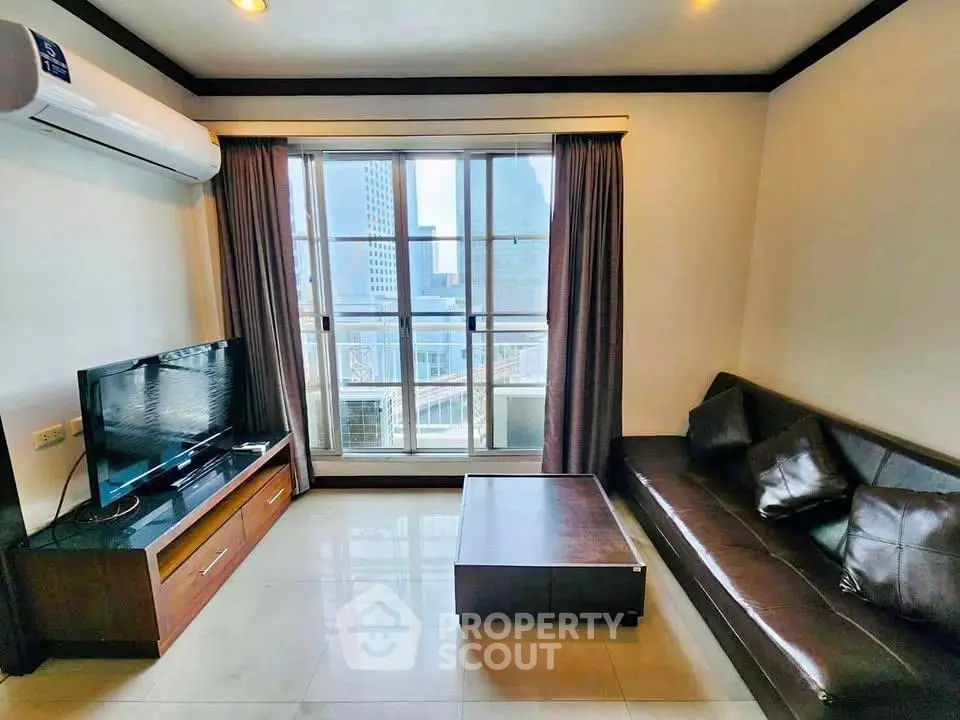Modern living room with city view, featuring sleek furniture and large windows for natural light.