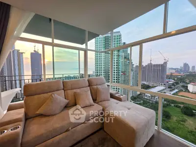 Luxurious living room with panoramic city and ocean views, featuring plush seating and floor-to-ceiling windows.