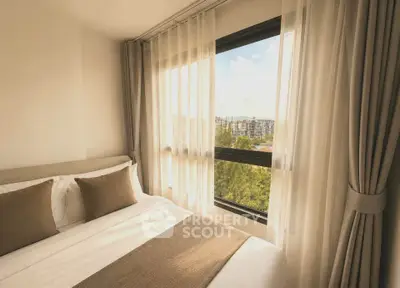 Cozy bedroom with large window offering stunning city view and natural light.