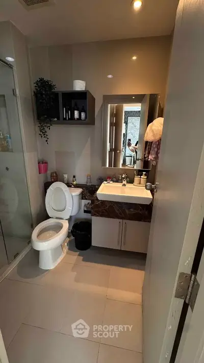 Modern bathroom with sleek fixtures and stylish decor, featuring a glass shower and elegant vanity.