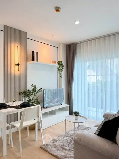 Modern living room with stylish decor, large window, and cozy seating area.