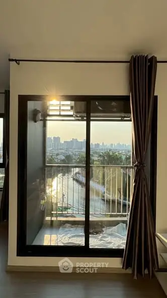 Stunning city view from modern apartment window with elegant curtains and natural light.
